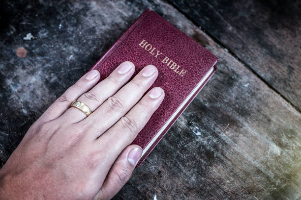 A human hand placed on the Bible