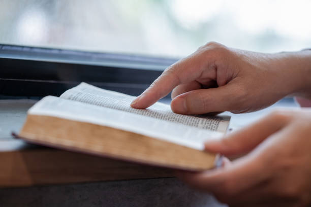 A closeup photo of hands of a man reading the Bible