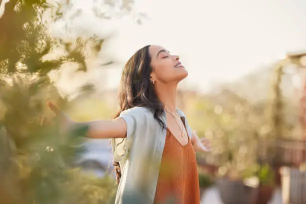 A young woman with hands outstretched depicting freedom through Christ