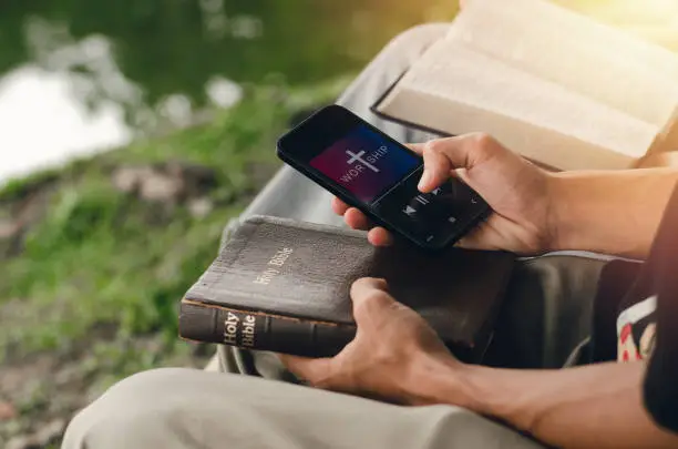 A man reading the Bible on the phone to illustrate leveraging technology to counter biblical illiteracy