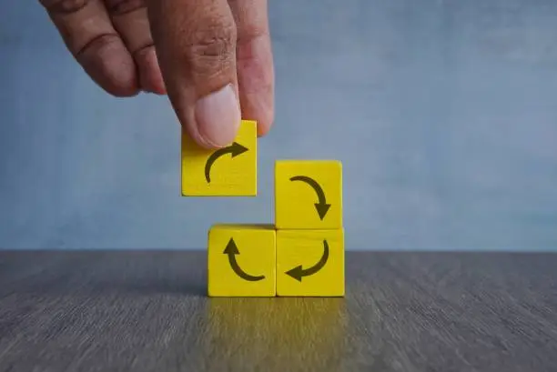 A hand dropping a piece of the puzzle to complete the repetition cycle to represent adopting strategic repetition in Bible retention hacks