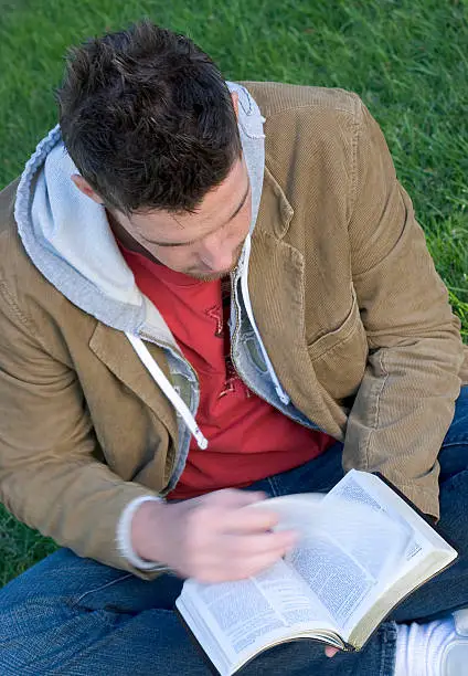 A man reading the Bible outdoors to conclude the Bible reading vs Bible study discussion