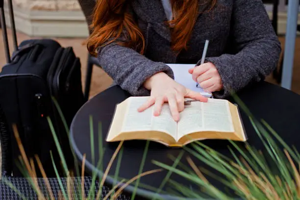 A young woman taking Bible notes