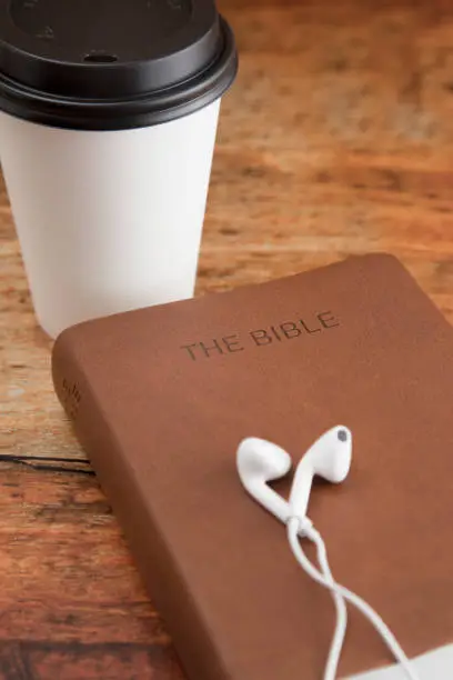 Wired earphones on a Bible as an illustration of songs boosting Bible retention