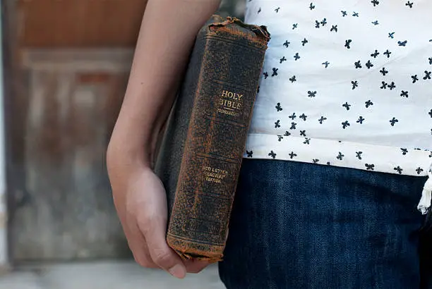 Someone holding an old Bible to illustrate fueling purpose and mission