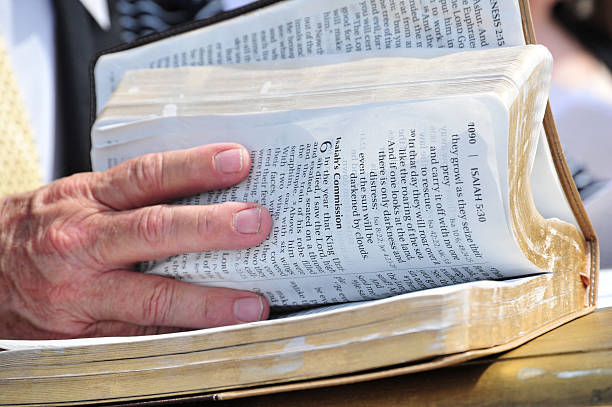Someone flipping the pages of a Bible through the book of Isaiah