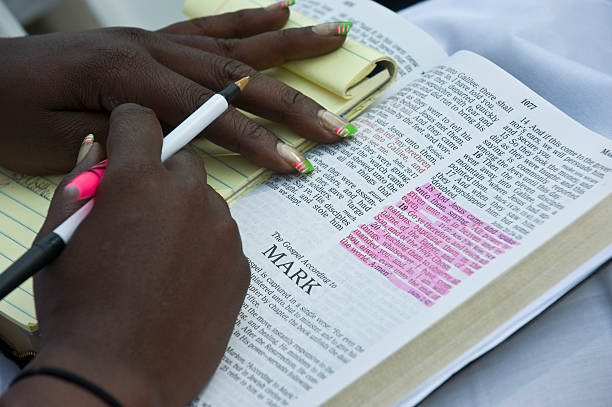 A woman's hands on a Bible preparing to take notes