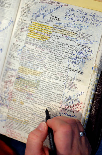 An open Bible with the book of John opened with notes scribbled
