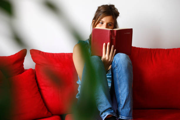 Young woman reading the bible at home to illustrate time of day least distracted