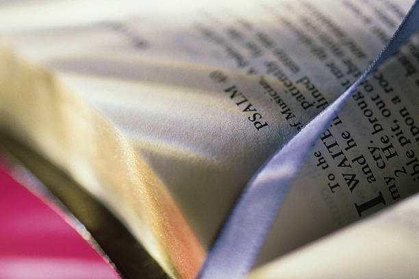 A Bible opened to the book of Psalm with a blue ribbon