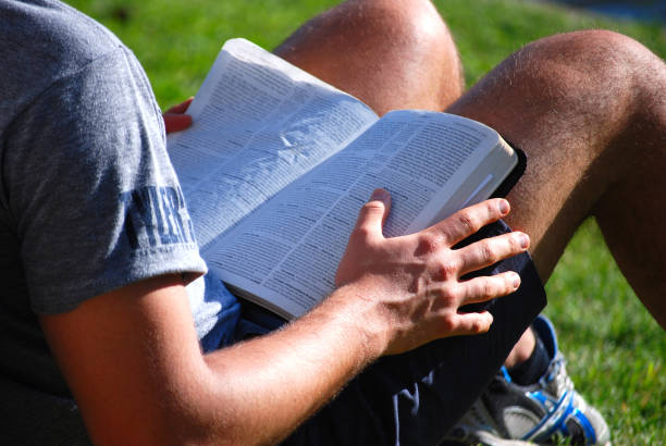 A young man reading the Bible outdoors